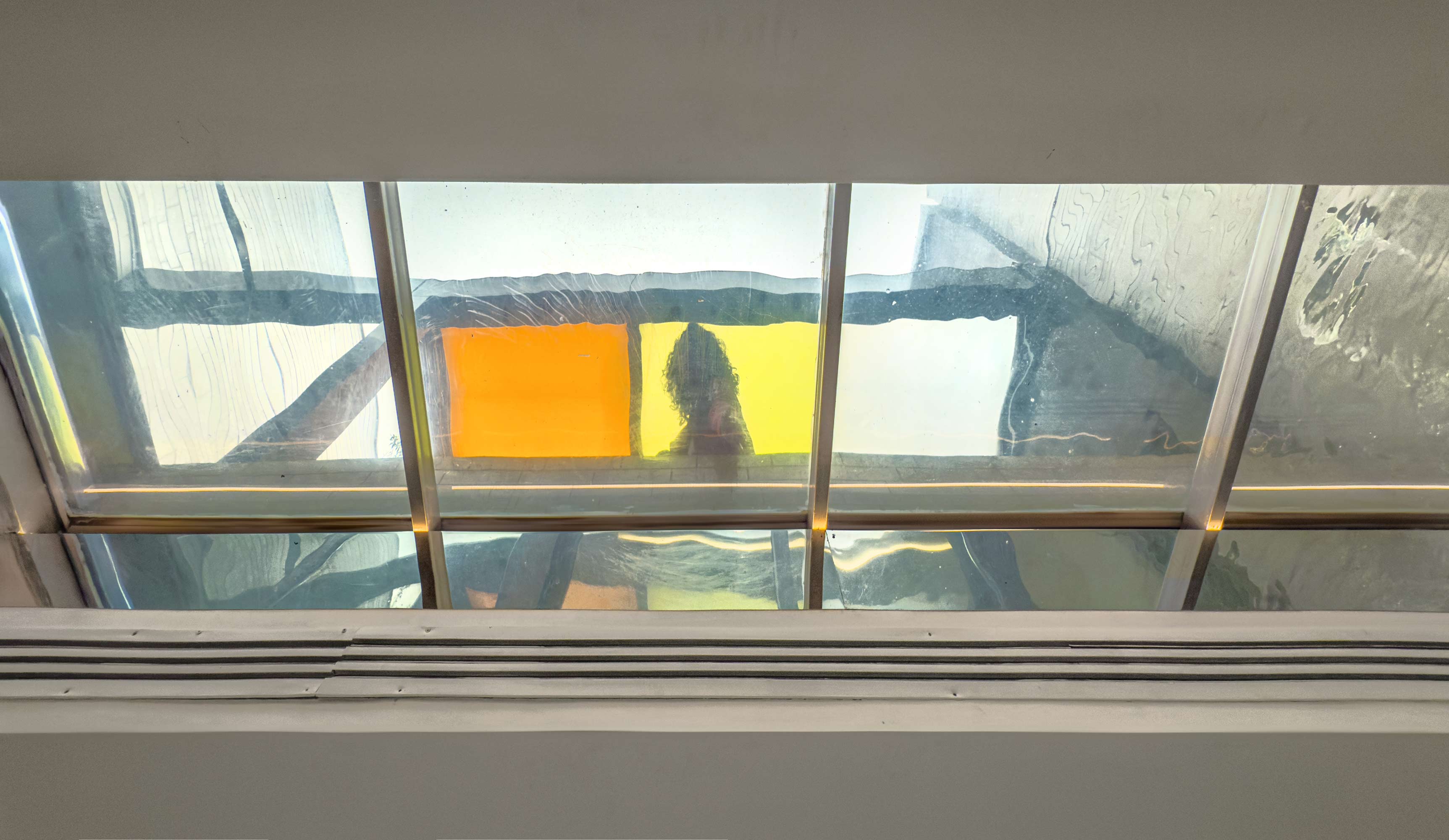 A shallow reflective pool with a transparent glass base, bringing daylight to the space underneath,Penthouse at the Jameh-Chin (Pleated Veil) Apartment