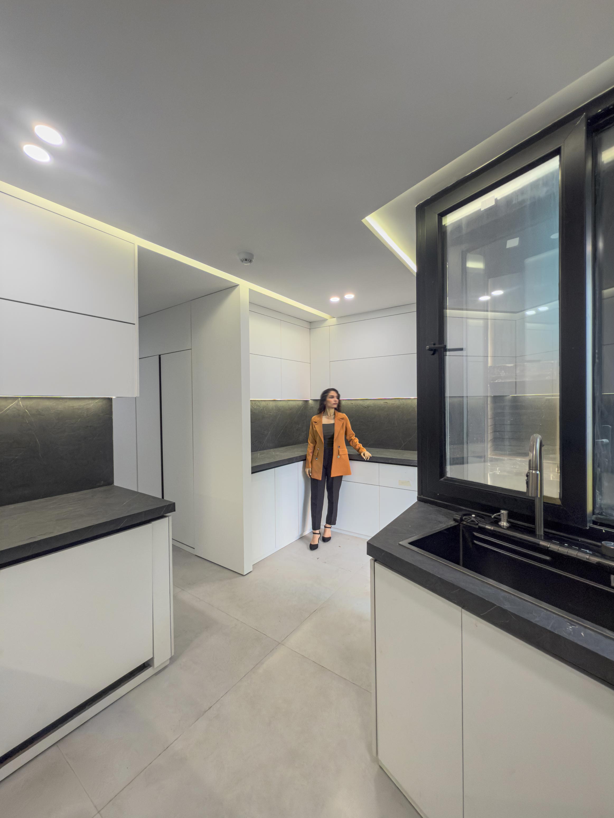 A person in the kitchen, the 1st and 2nd floor, the Jameh-Chin (Pleated Veil) Apartment,100 St, Rasht, Iran